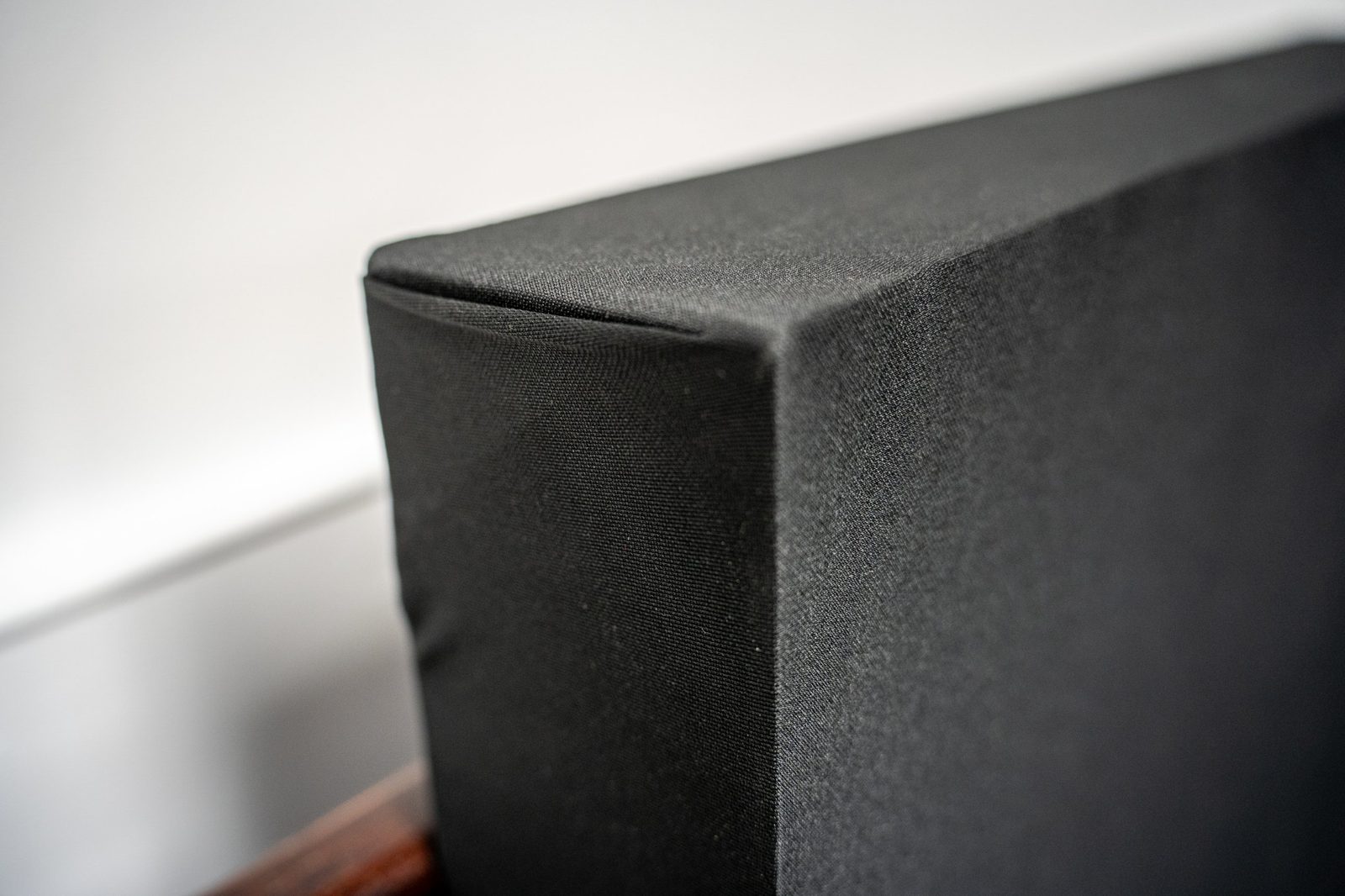 Close-up of a finished Studio 12 acoustic panel corner, showing the fabric-wrapped edge and mitred seam