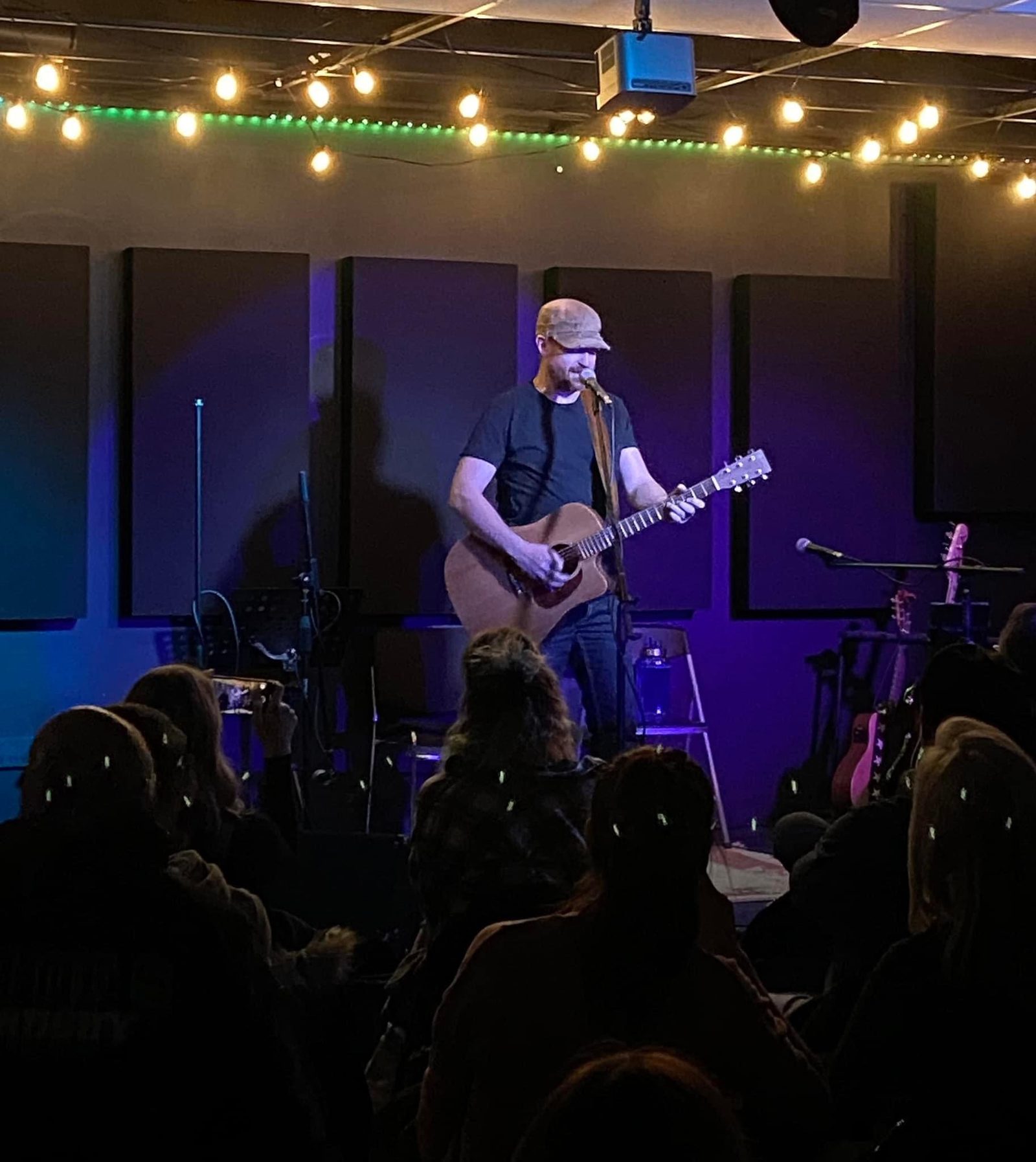 Studio 12 acoustic panels mounted on a wall behind a performer during a live show